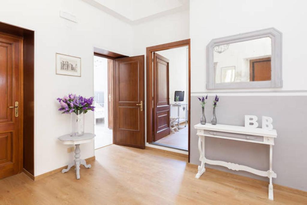 a room with a mirror and a table with flowers on it at Domus Merulana Bed and Breakfast in Rome