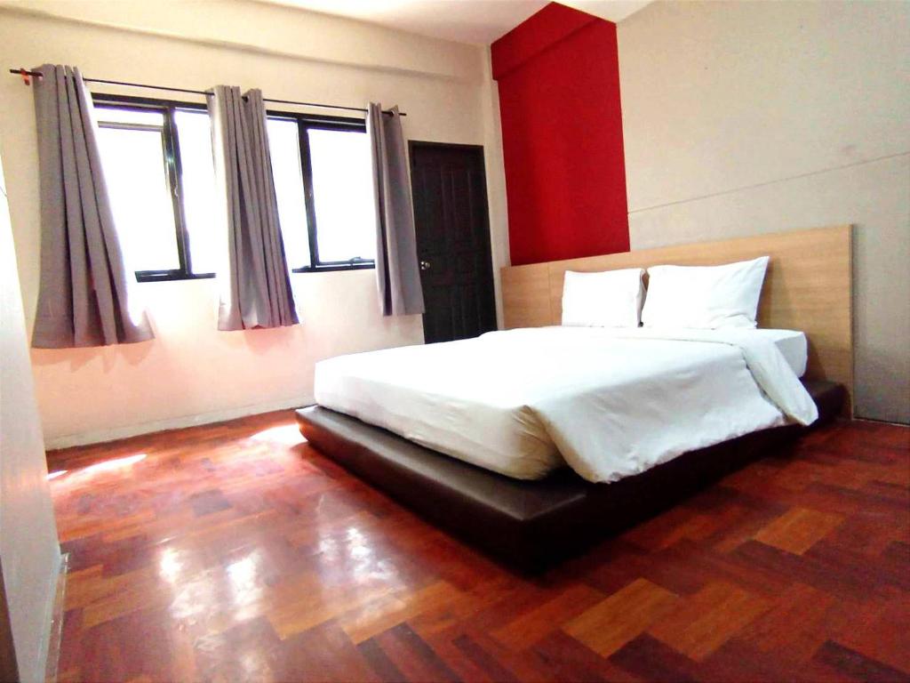 a bedroom with a white bed and two windows at GO INN Silom - BTS Surasak station in Yan Nawa