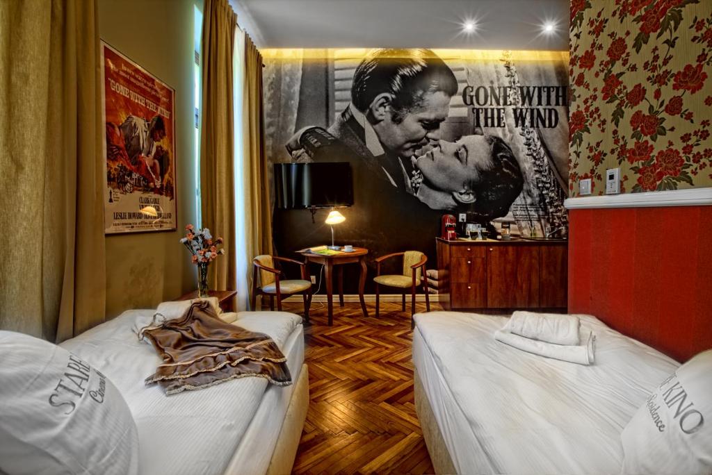 um quarto com 2 camas e um cartaz de filmes em Stare Kino Cinema Residence em Lódź