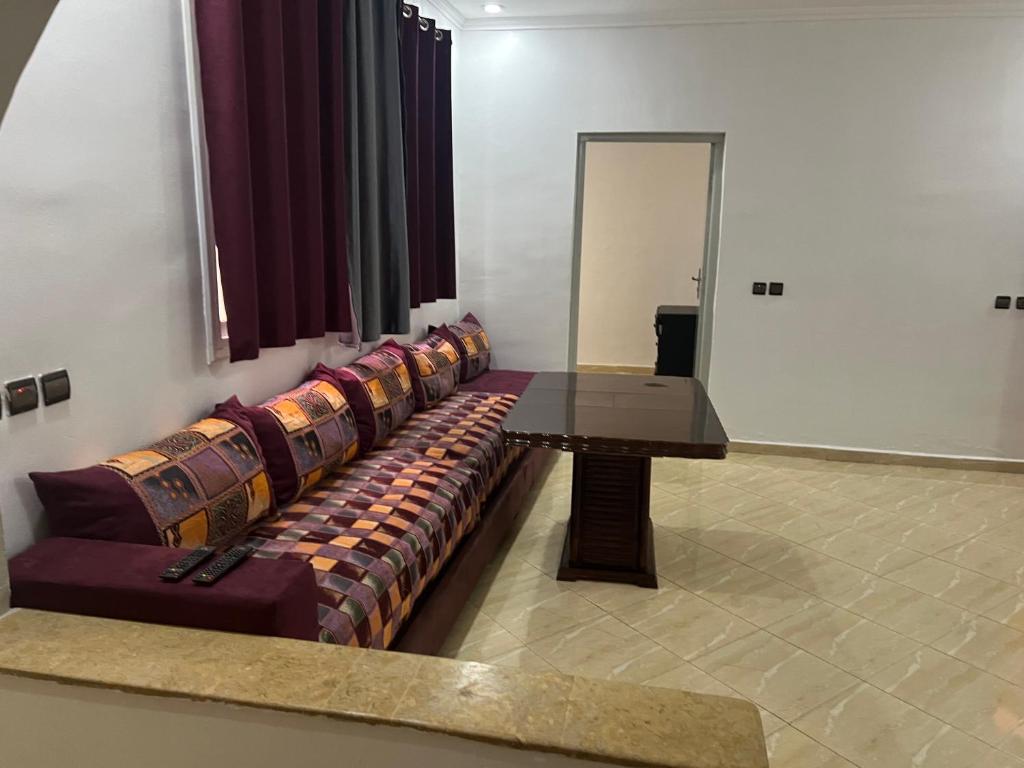 een woonkamer met een bank en een tafel bij Appartement 2 en rez-de-chaussée in Oujda