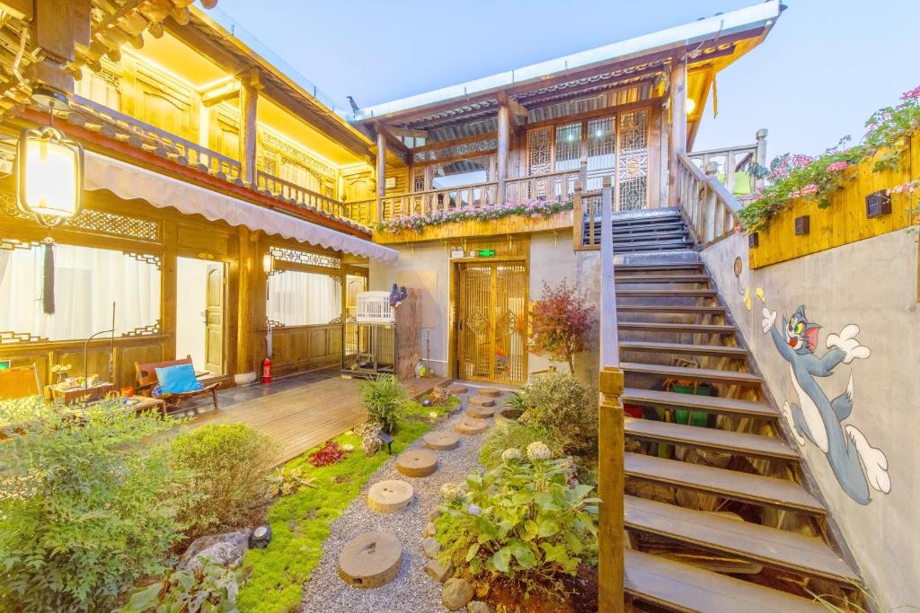 a building with a staircase in a yard at Gegewu Inn - Lijiang Ancient Town in Lijiang