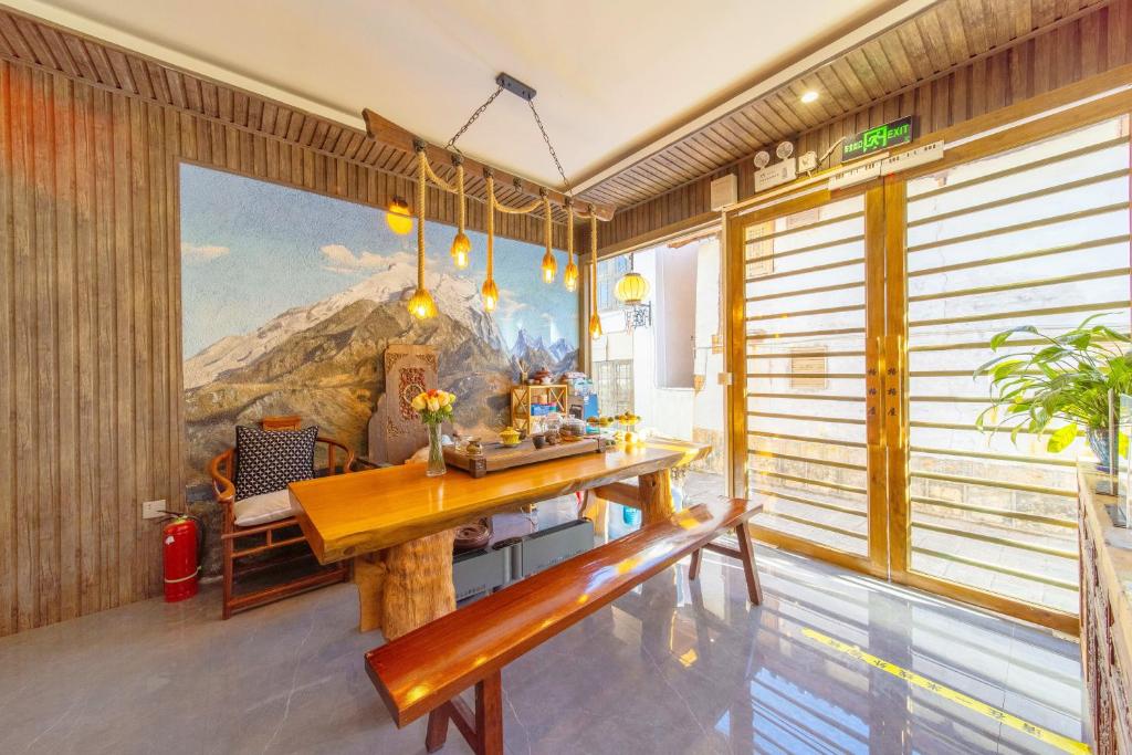 a dining room with a wooden table and a bench at Gegewu Inn - Lijiang Ancient Town in Lijiang
