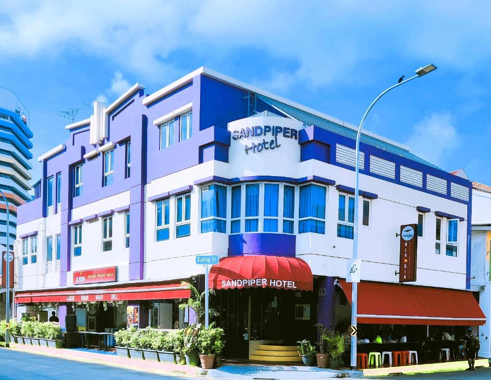 a blue and white building on a city street at Sandpiper Hotel Singapore in Singapore