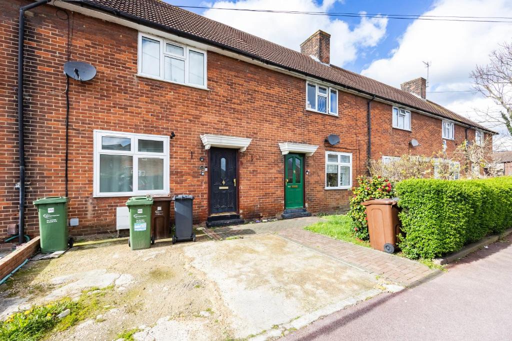 a brick house with two trash cans in front of it at Heads on Bed - Dagenham 3Bedrooms House walk to Station with Parking in Dagenham