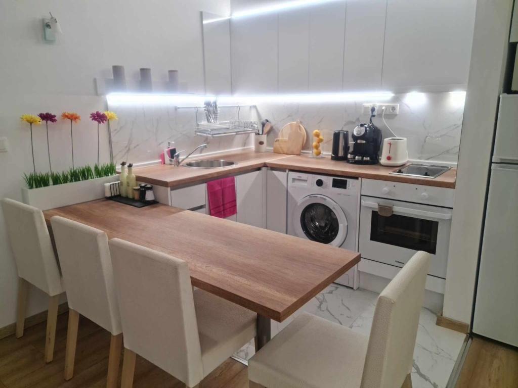 a kitchen with a wooden table and white appliances at Aglaya 2 - Pomorie Bay in Pomorie