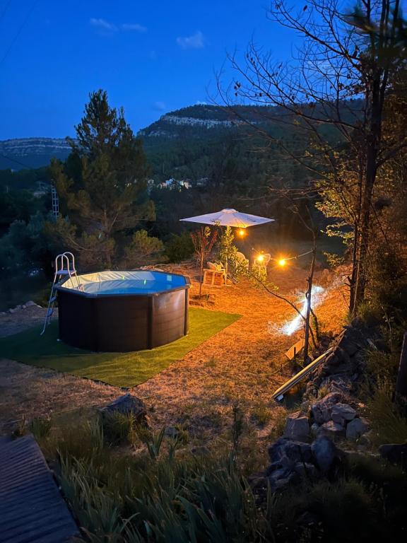 a hot tub in the middle of a yard at night at Casa Rural La Garcia in Puebla de Arenoso