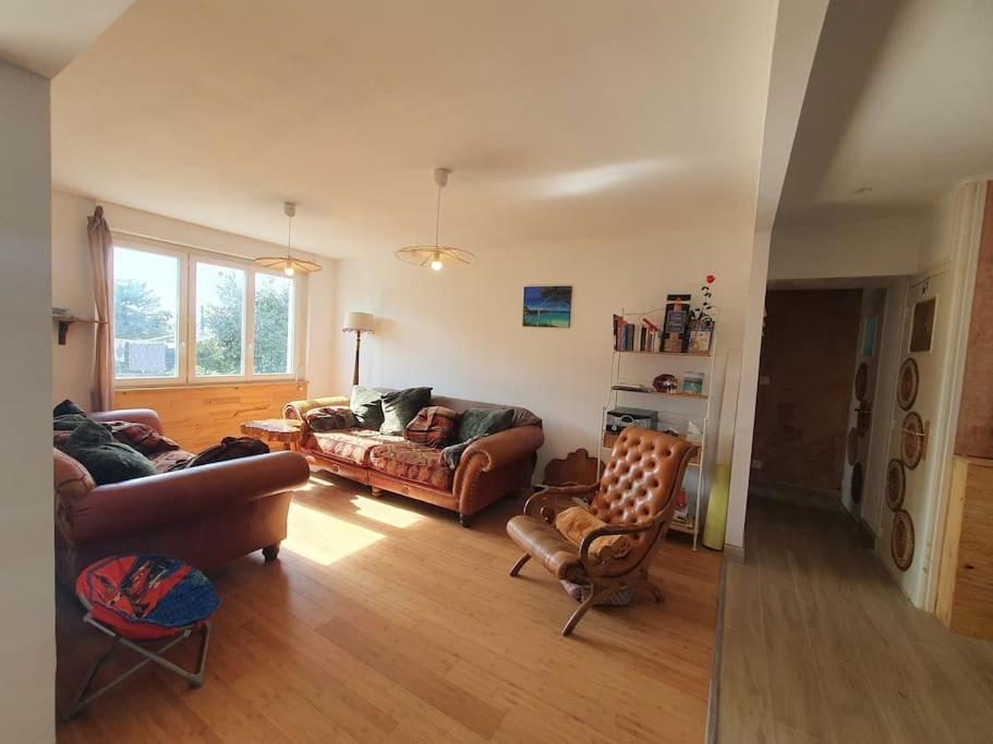 a living room with couches and chairs in a room at Gîte Thera Cottage 3 étoiles in Le Vieux-Bourg