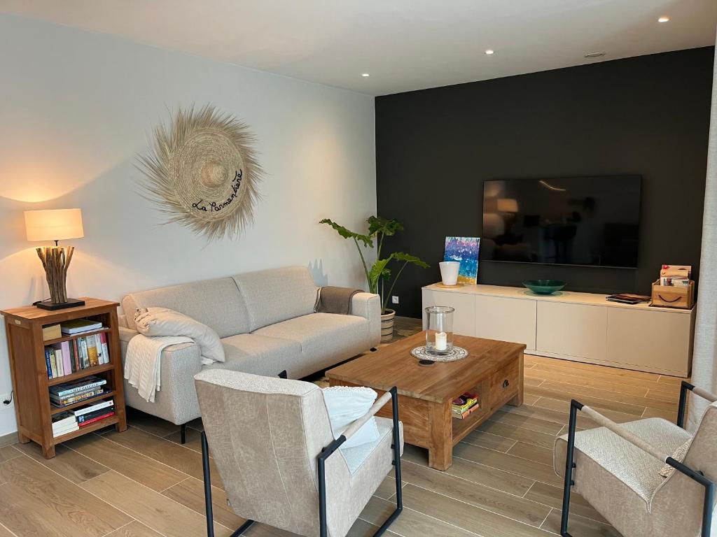 uma sala de estar com um sofá e uma mesa em Logies La Parmentière em De Panne