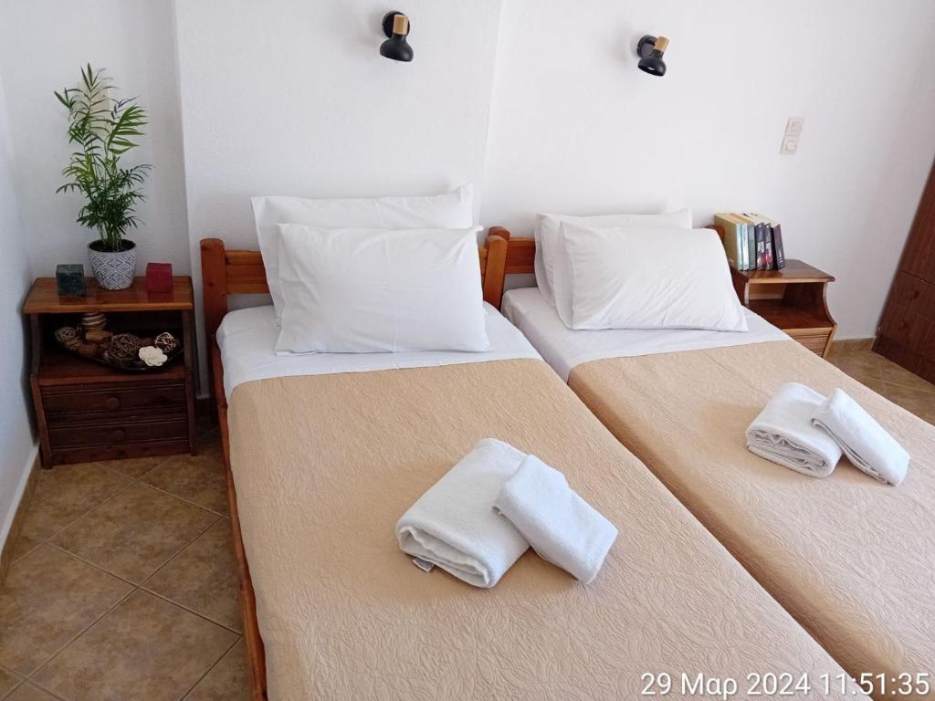 two beds in a room with towels on them at Happy Days in Agia Galini