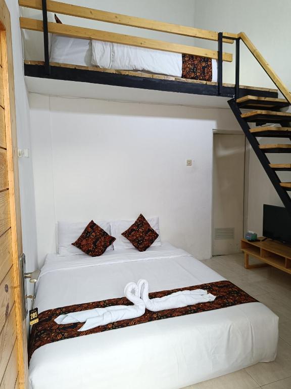 a bedroom with two bunk beds and a ladder at Jogja Amor Hotel in Demangan