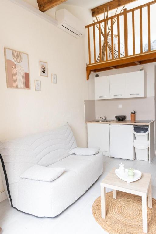 - une chambre blanche avec un lit blanc et une table dans l'établissement Maisonnette au calme, à Villeneuve-Loubet