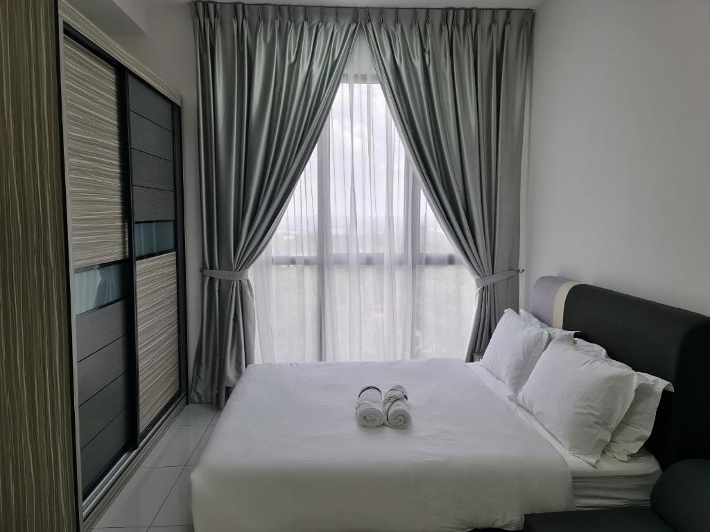 a bedroom with a bed with two wedding shoes on it at Sky Tree Studio Apartment at Bukit Indah, Johor in Johor Bahru