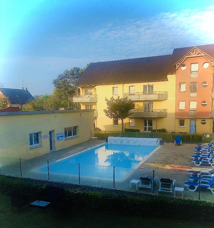 une piscine devant un immeuble dans l'établissement Ma Pause Normande T3 Les Isles de Sola, à Grandcamp-Maisy