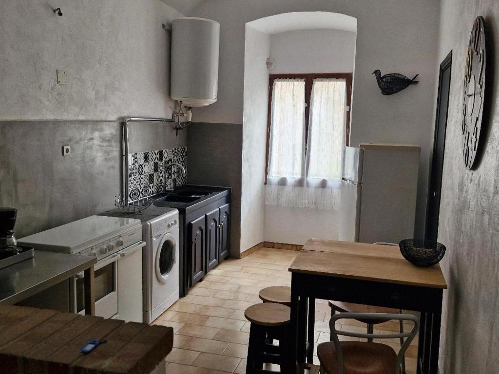 a kitchen with a table and a stove top oven at Appartement centre Saint Florent in Saint-Florent