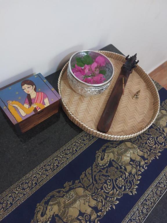 a table topped with a bowl of flowers and a knife at Baksaei Retreat Ricefield Villas in Kampot