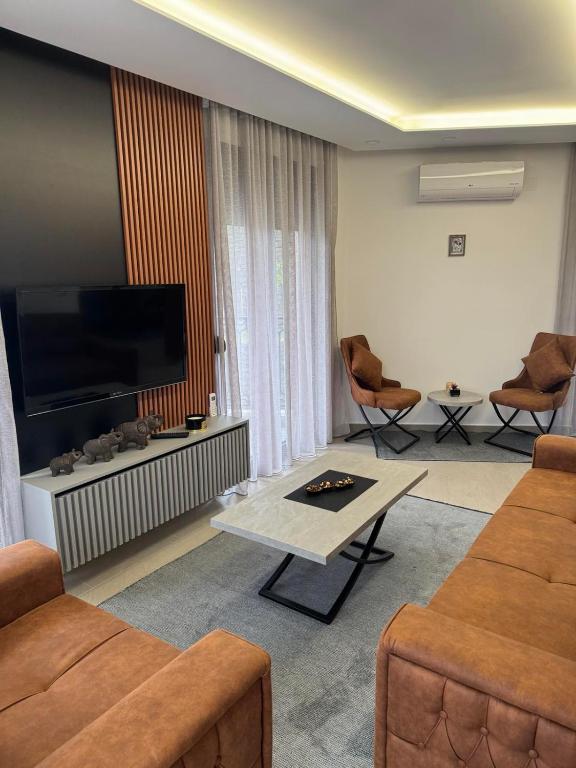 a living room with a tv and a couch and a table at Apartman ANNA ATINA Budva in Budva