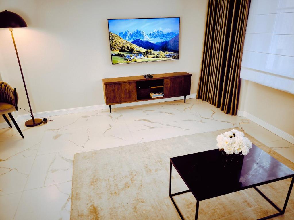 a living room with a tv on a wall at Central Apartments Ogarna 5 in Gdańsk