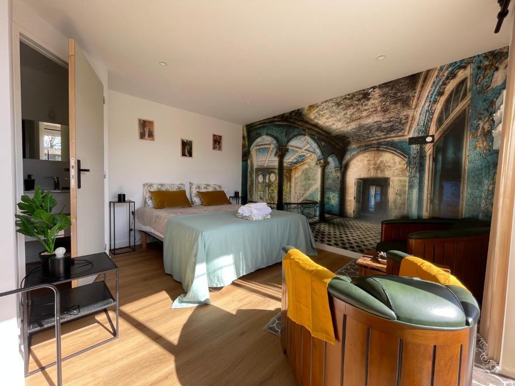 ein Schlafzimmer mit einem Bett und einem Wandbild in der Unterkunft RELAI DU CHATEAU APPARTHOTEL in La Tourlandry