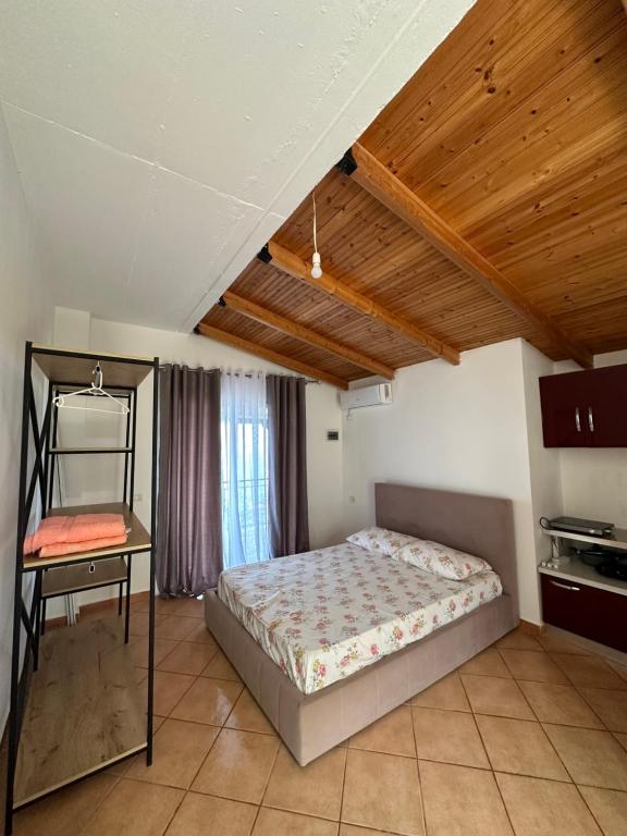 1 dormitorio con cama y techo de madera en Evita's House, en Lukovë