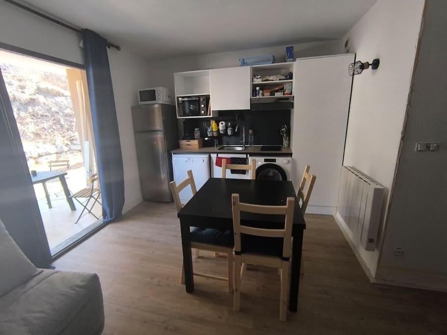 a kitchen with a table and chairs in a room at studio tout équipé in Jausiers