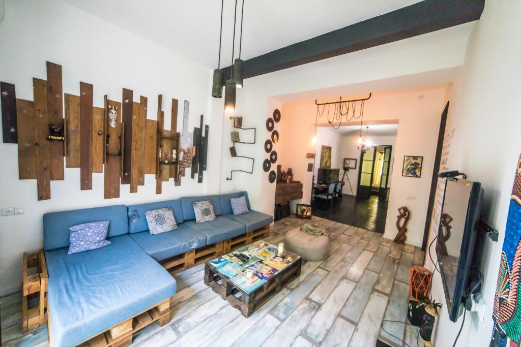 a living room with a blue couch and a table at Loft Style Apartment in Tbilisi City