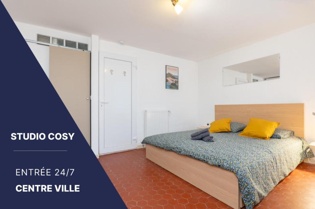 a bedroom with a bed with yellow pillows at Magnifique studio cosy et calme in Digne-les-Bains