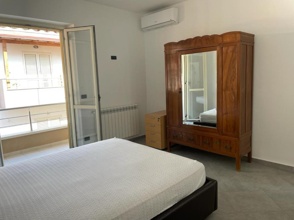 1 dormitorio con cama, tocador y espejo en Casa vacanze Marinella en Bagnara Calabra