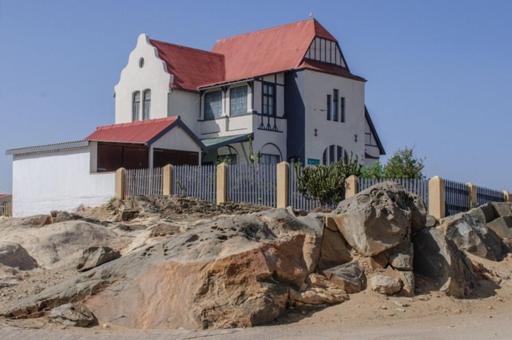 uma casa no topo de uma colina com uma cerca em Haus Panorama-3 bedrooms with great views em Lüderitz