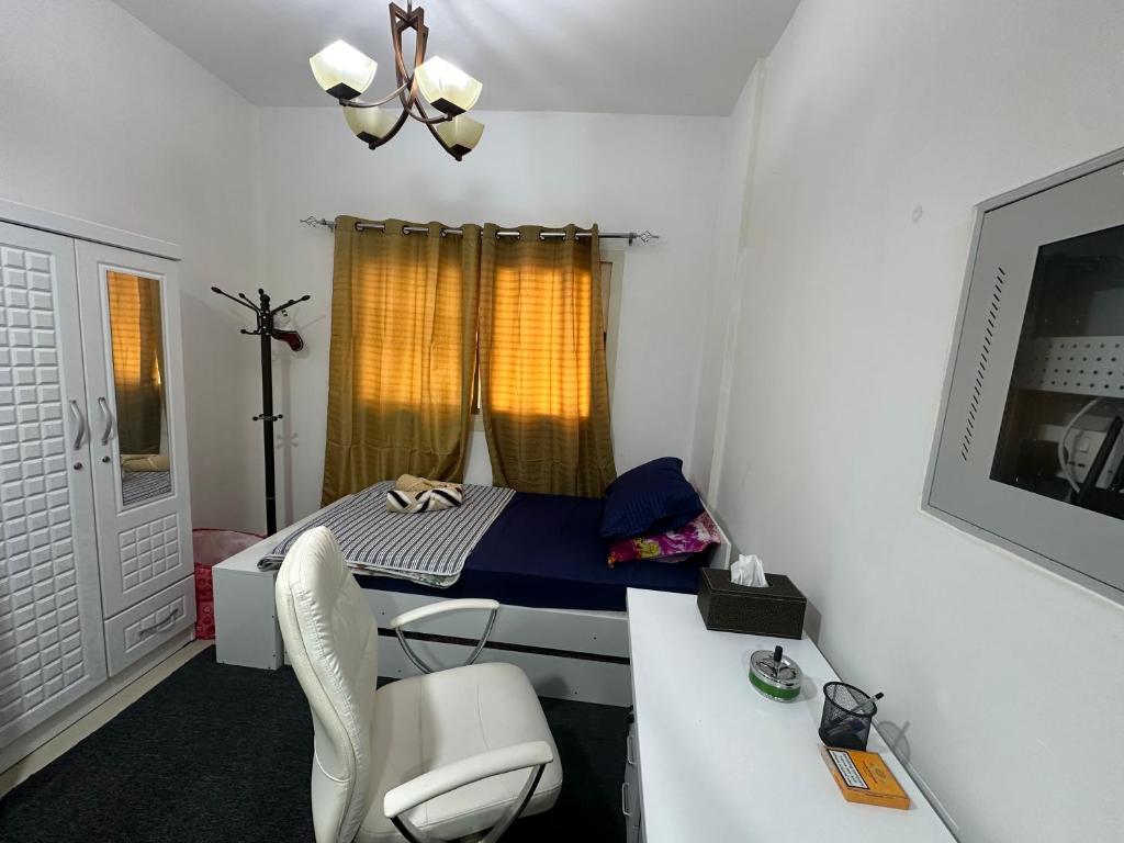 a room with a bed and a desk with a chair at The Regal Residency Studio, 1 Minute Walking Distance from Gold Souk in Dubai