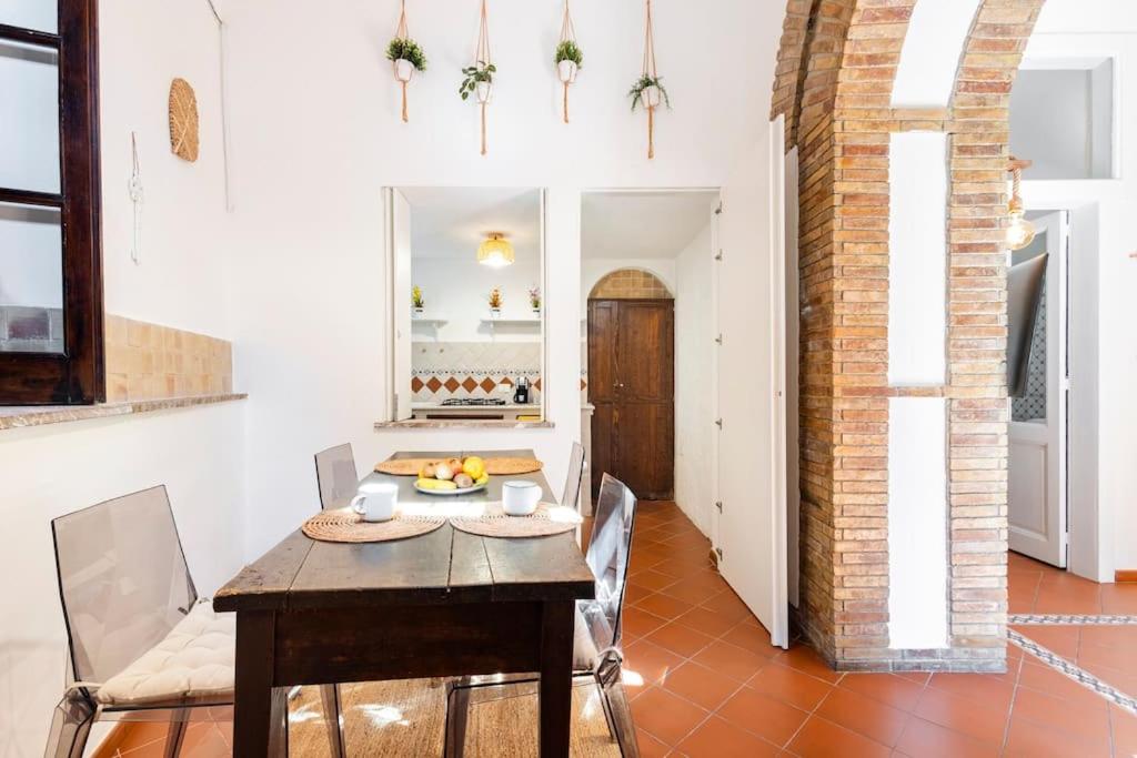 een eetkamer met een tafel en stoelen en een keuken bij BOHEMIAN - Taormina Central Apartment in Taormina