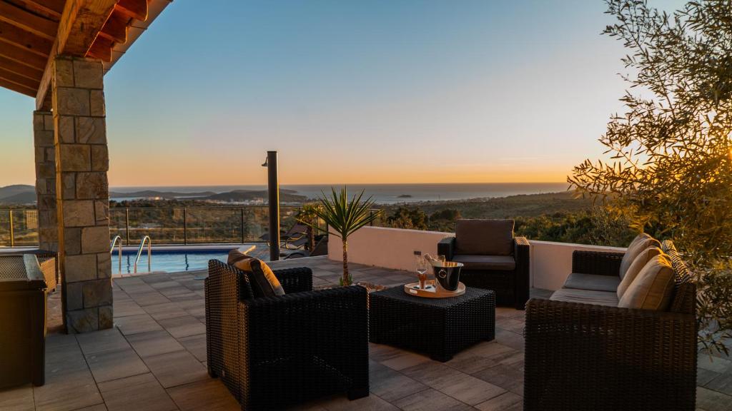 une terrasse avec des chaises, une table et une piscine dans l'établissement Villa Alacinda, à Rogoznica