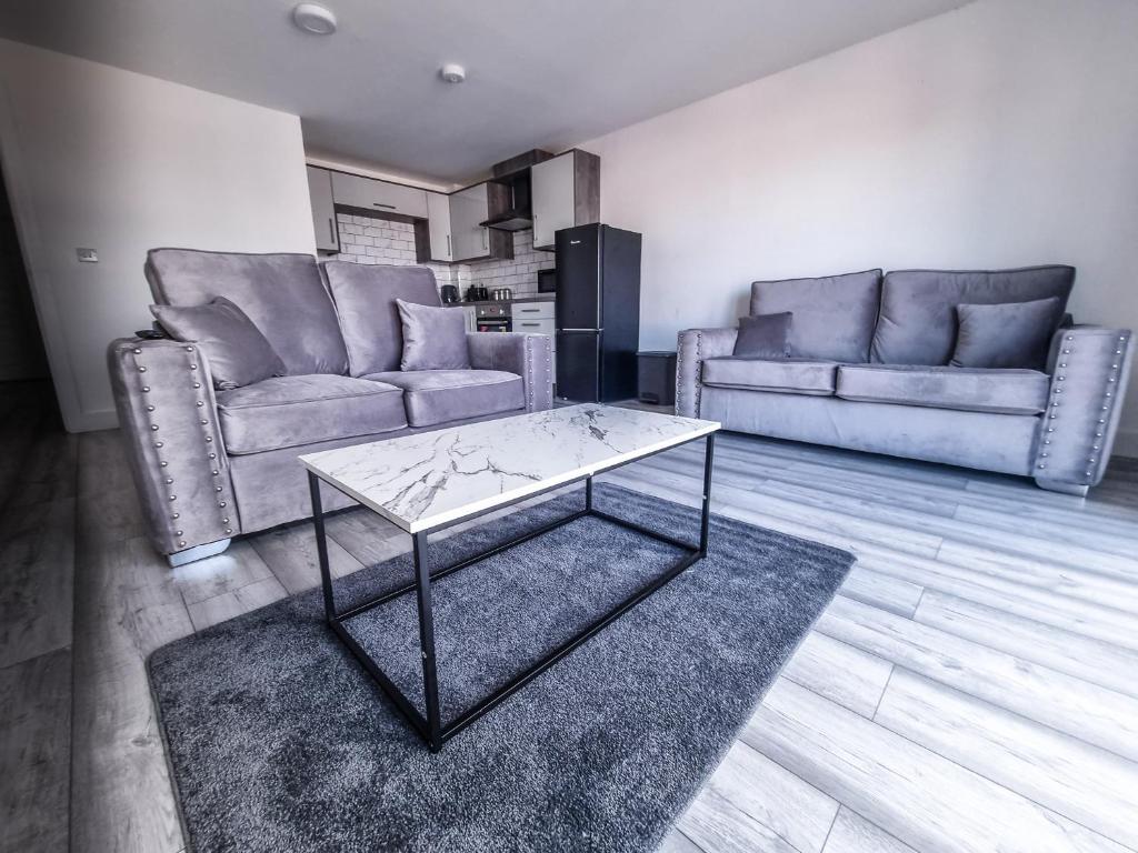 a living room with two couches and a coffee table at Elegant City Apt: 1-BR Luxury in Wolverhampton