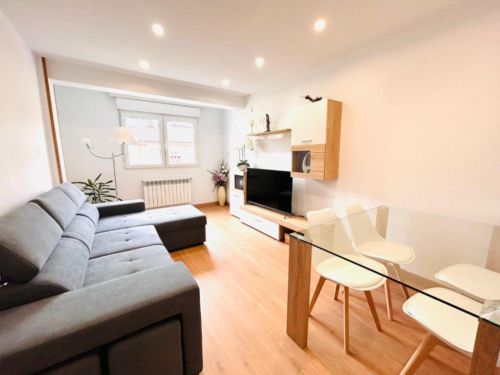 a living room with a couch and a glass table at Apartamento San José in Milladoiro