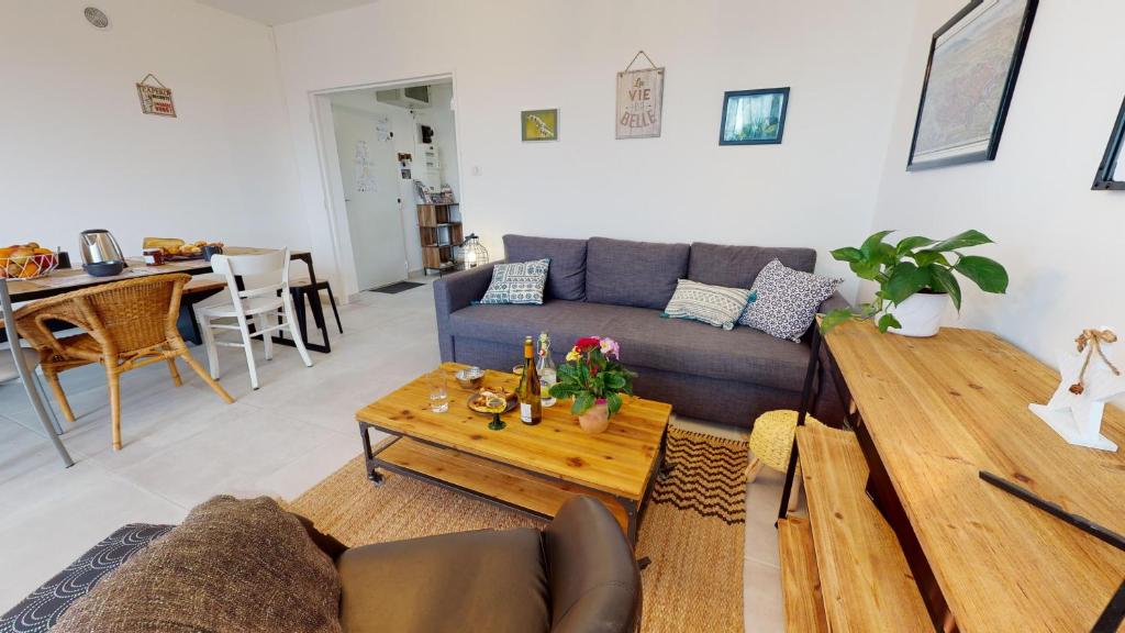 un salon avec un canapé et une table dans l'établissement Le Marcellin Colmar - Garage - Terrasse, à Colmar