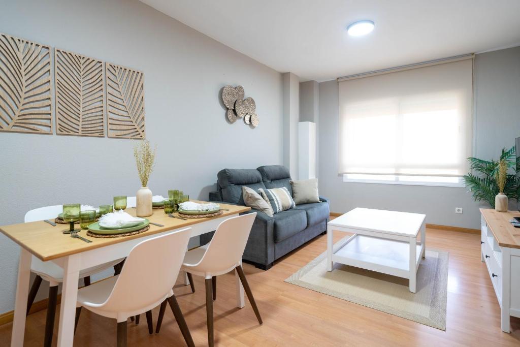 sala de estar con mesa y sofá en Apartamentos GO Covaresa -Parking Gratuito, en Valladolid