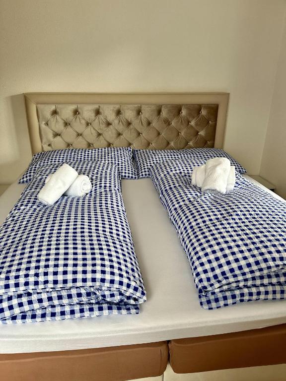 a bed with blue and white checked sheets and towels at Haus Christania, Obergeschoss, Unterbäch Wallis in Unterbäch