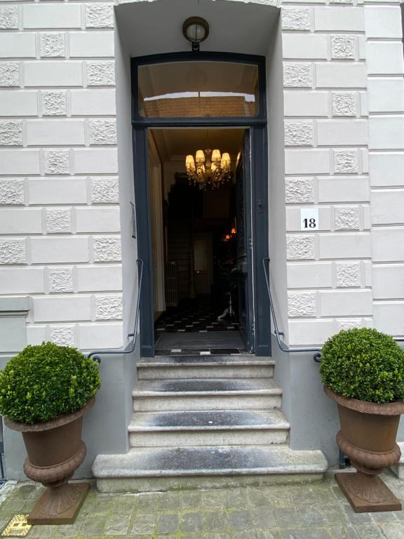 a doorway to a building with stairs and a chandelier at Amato-Brugge in Bruges