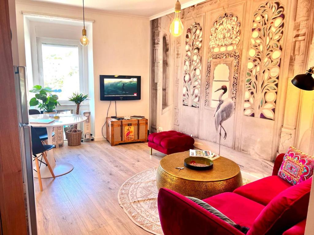 リスボンにあるCharm and Comfort Apartment 46 by Lisbonne Collectionのリビングルーム(赤いソファ付)
