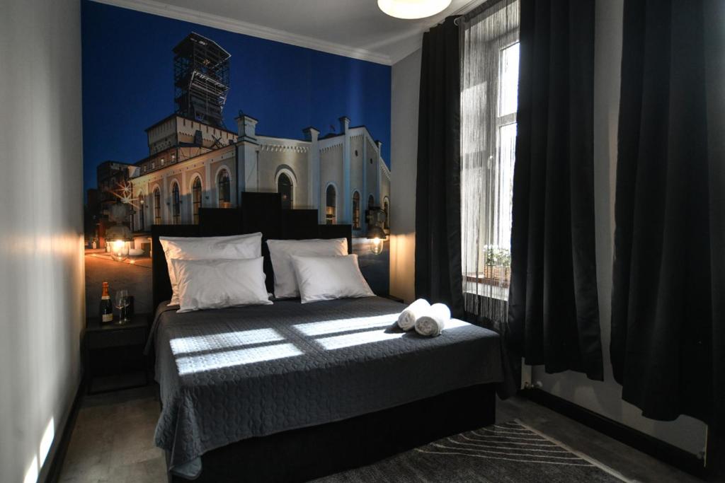 ein Schlafzimmer mit einem Bett und einem Gebäude an der Wand in der Unterkunft Apartament Kopalnia przy Zamkowej w Wałbrzychu in Wałbrzych