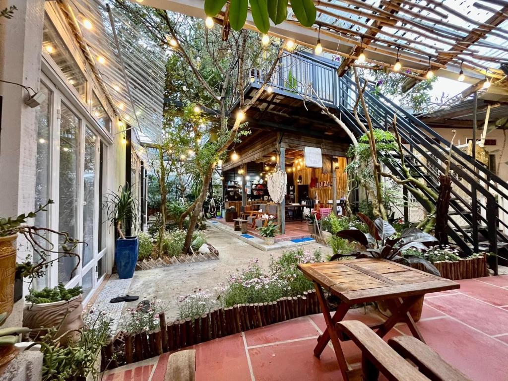 eine Terrasse mit einem Tisch, einer Treppe und Pflanzen in der Unterkunft Joyz House Da Lat in Da Lat