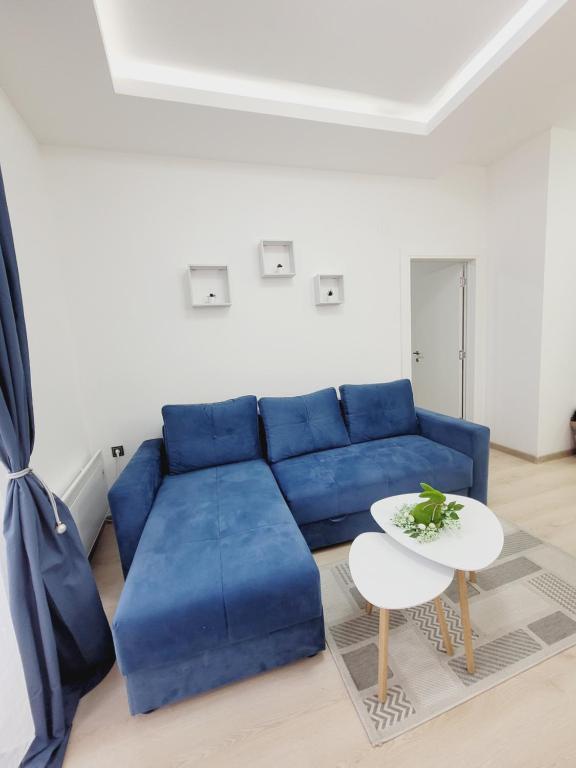 ein blaues Sofa im Wohnzimmer mit einem Tisch in der Unterkunft Apartman Royal in Zlatibor