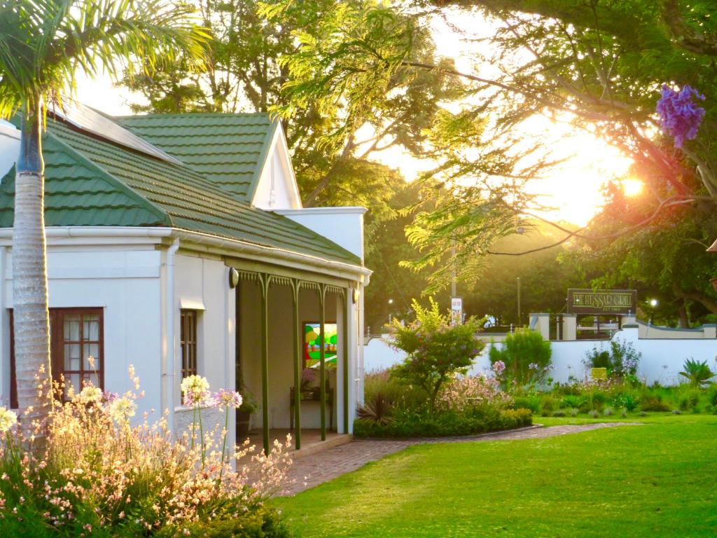 a white house with a green roof at Whistlewood Guesthouse Walmer, Port Eizabeth in Port Elizabeth