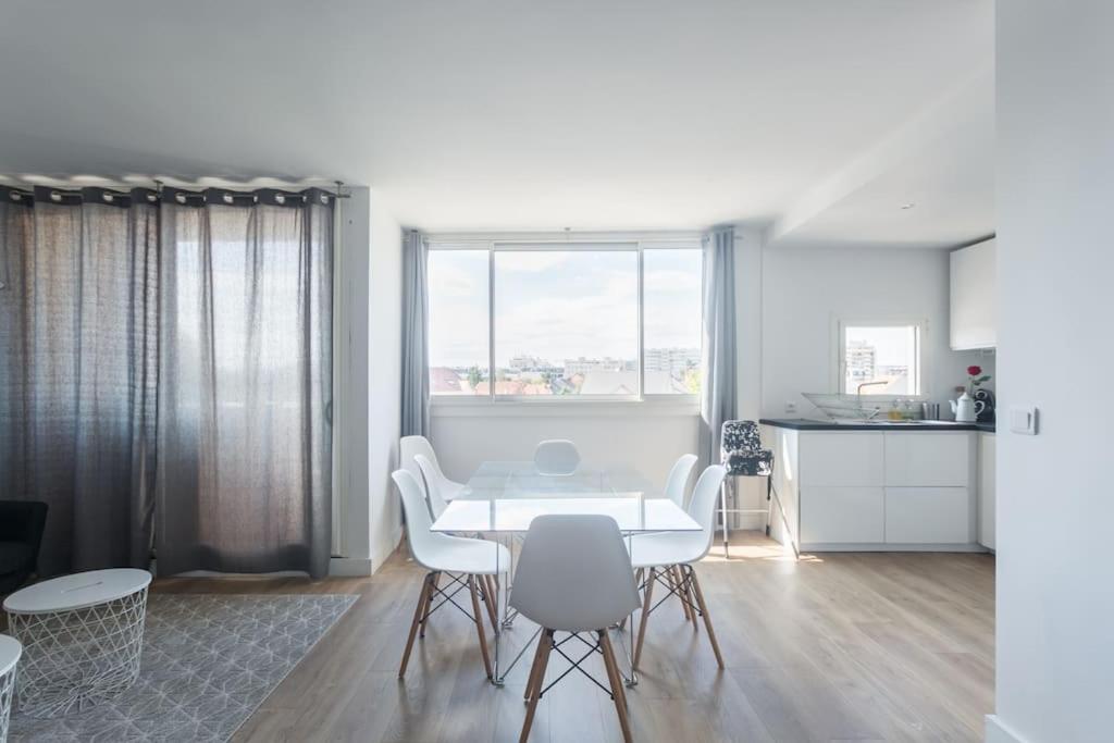 une salle à manger blanche avec une table et des chaises blanches dans l'établissement Joli Duplex rénové à neuf de 72m², à Fresnes