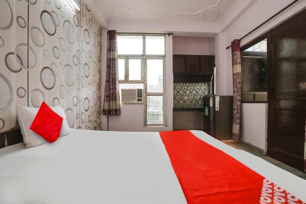 a bedroom with a large white bed with a red blanket at OYO Flagship Corporate House in Gurgaon
