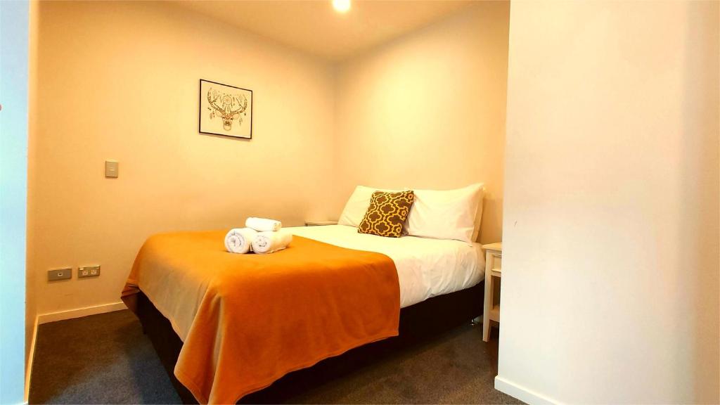 1 dormitorio con 1 cama con 2 toallas en Sky Stars Essential Home, en Auckland