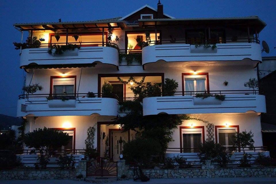 a three story white building with lights on it at Elenas Apartments in Plataria