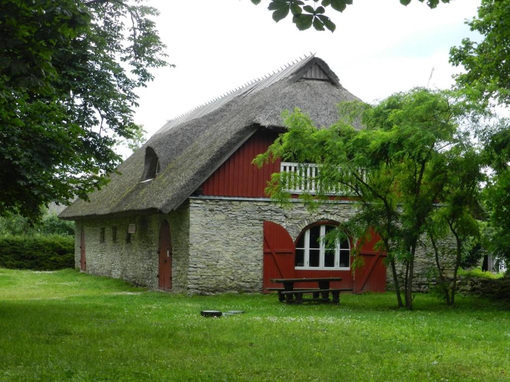 a barn with a red roof and a bench in front of it at Saare Guest Apartment in Saare