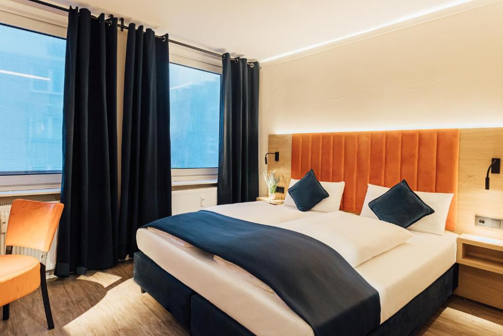 a hotel room with a large bed and a window at City Hotel St. Georg Hamburg in Hamburg