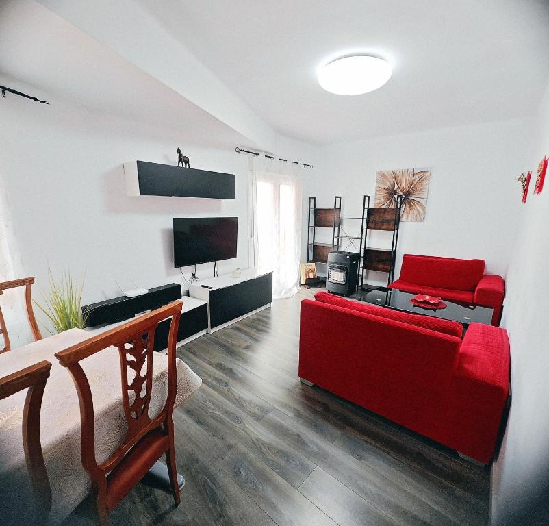 sala de estar con sofá rojo y TV en Royal Family Apartment, en Chirivella