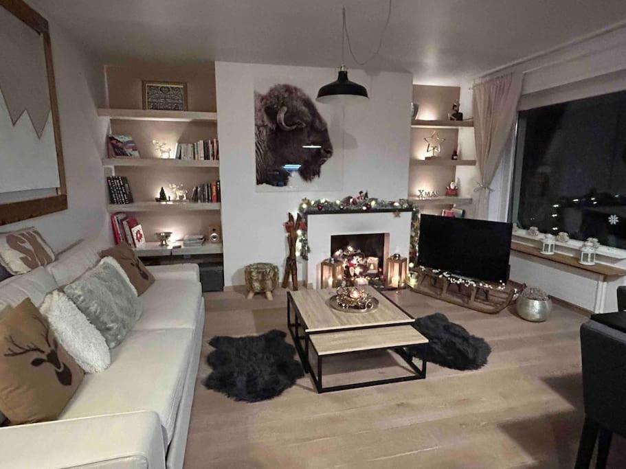 uma sala de estar com um sofá branco e uma lareira em A 2 min. à pied du centre de Crans et des remontée em Lens